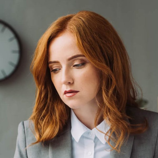 redhead-female-lawyer-looking-at-paper-sheet-whil-2023-01-30-22-59-21-utc